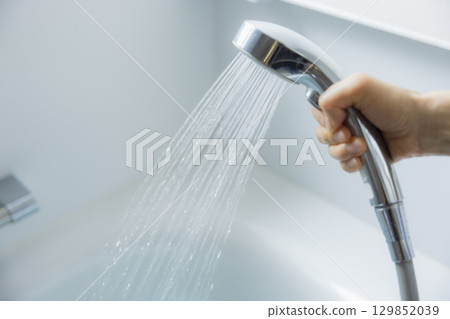 女人的手拿著淋浴噴頭 女人的手拿著淋浴噴頭 129852039