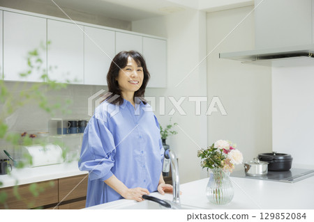 Woman holding a vase in the kitchen 129852084