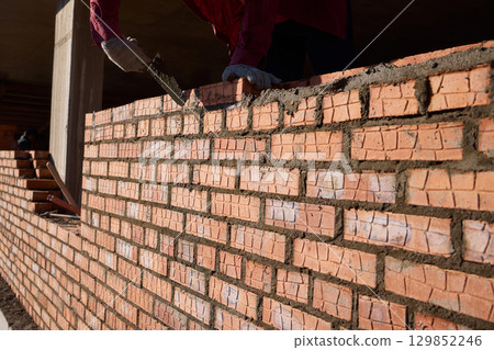 Bricklayer Hard at Work Ongoing Construction of a Residential Building Structure 129852246