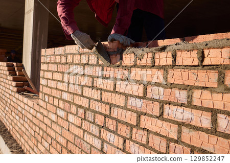Bricklayer Hard at Work Ongoing Construction of a Residential Building Structure 129852247