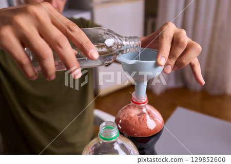 A Young Scientist Conducting a Home Experiment with Proper Safety Gear for Protection A Young Scientist Conducting a Home Experiment with Proper Safety Gear for Protection 129852600
