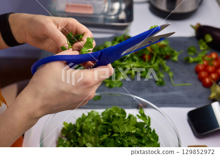 Hands Skillfully Cutting Fresh Cilantro for Delicious and Flavorful Cooking Dishes Hands Skillfully Cutting Fresh Cilantro for Delicious and Flavorful Cooking Dishes 129852972