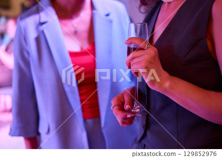 Elegant Hand Holding a Glass of Ros Champagne at an Event 129852976