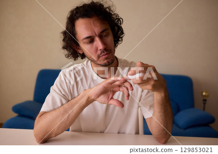 Close-up of an electric nail clipper in hand, modern personal care technology, highlighting compact design and functionality, modern gadget for personal grooming 129853021