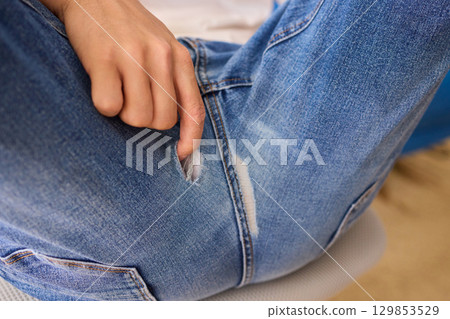 Casual Denim Wear Featuring a Special Emphasis on the Torn Jeans Detail and Design Elements Casual Denim Wear Featuring a Special Emphasis on the Torn Jeans Detail and Design Elements 129853529