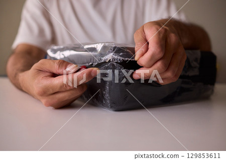 Unboxing a New Electronic Device with Great Care and Attention to Detail and Excitement 129853611