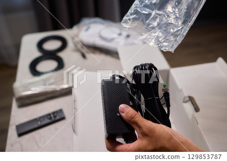 Unboxing a Brand New Electronic Device Along with Its Accessories and Remote Control 129853787