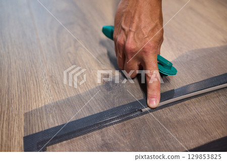 The process of cutting vinyl flooring accurately is essential for achieving a perfect fit 129853825