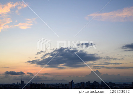 At dawn in Toshi, the sun rises through the gaps between the buildings, casting the area in an orange hue and making the buildings appear as silhouettes. 129853922