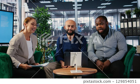 Corporate web video conference with diverse participants focused on goal oriented business growth, remote consulting and functional team interaction via online communication tools. Camera A. 129854051