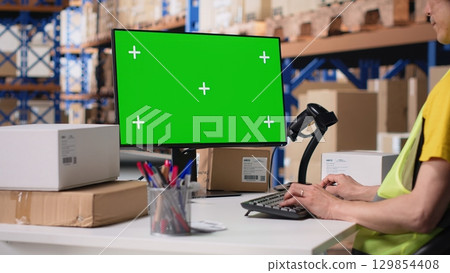 Asian employee uses a isolated mockup screen on computer monitor, business software used for supply chain system and package tracking service. Real-time order fulfillment. Camera B. 129854408