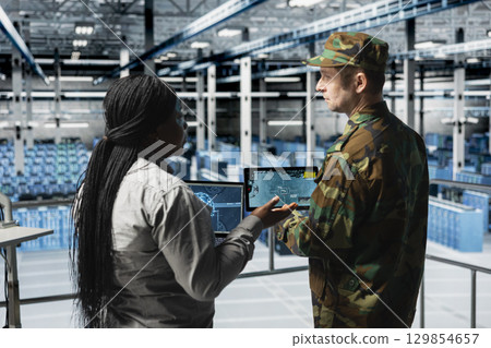 Army soldiers in data center visualizing ballistic missiles flight patterns with artificial intelligence. Military units in server room enhancing situational awareness through AI detection systems Army soldiers in data center visualizing ballistic missiles flight patterns with artificial intelligence. Military units in server room enhancing situational awareness through AI detection systems 129854657