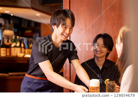 Izakaya: Male staff serving drinks Izakaya: Male staff serving drinks 129854679