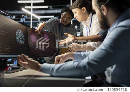 Programmers in AI data center reacting to virus alert, initiating protocol to protect critical systems. Server room IT experts doing brainstorming, assessing compromised gear after hacker attack 129854718