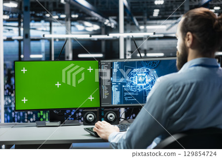 Engineer in data center managing AI training datasets using isolated screen PC monitor. Man using mockup PC display to oversee machine learning in server room supporting scalable infrastructure for AI Engineer in data center managing AI training datasets using isolated screen PC monitor. Man using mockup PC display to oversee machine learning in server room supporting scalable infrastructure for AI 129854724