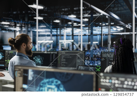 Data center computer scientist working on databases supporting AI applications. IT worker in server room conducting experiments on artificial intelligence algorithms improvements 129854737
