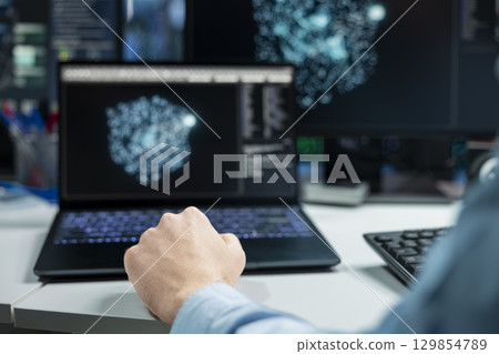 Close up of data center developer using laptop, monitoring AI systems, adjusting machine learning parameters. Server room IT professional using notebook, enhancing artificial intelligence performance Close up of data center developer using laptop, monitoring AI systems, adjusting machine learning parameters. Server room IT professional using notebook, enhancing artificial intelligence performance 129854789
