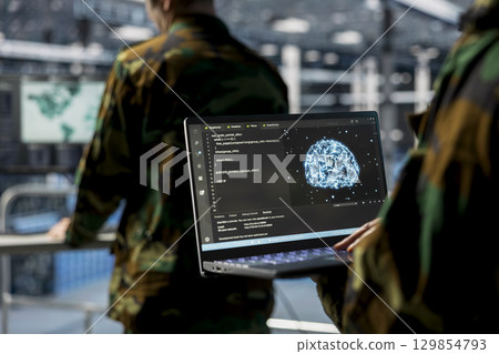 Close up of server hub employee in soldier uniform using laptop, running AI tools. Army information technology specialist in data center deploying machine learning models for battlefield analytics 129854793