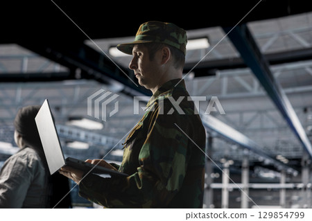 Army information technology expert in data center configuring encrypted servers to protect sensitive defense data. Soldier in command center server room managing military IT infrastructure Army information technology expert in data center configuring encrypted servers to protect sensitive defense data. Soldier in command center server room managing military IT infrastructure 129854799