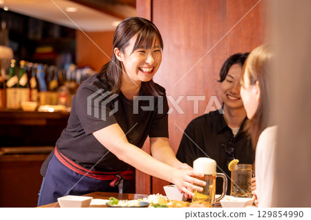 居酒屋:女店員為顧客提供飲料 居酒屋:女店員為顧客提供飲料 129854990