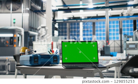 Chroma key display on tablet in photovoltaics facility used for solar panels, overseeing performance metrics and production line. Empty industrial factory for high tech machinery. Chroma key display on tablet in photovoltaics facility used for solar panels, overseeing performance metrics and production line. Empty industrial factory for high tech machinery. 129855253