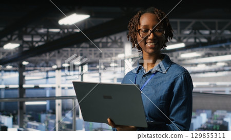 Portrait of joyful computer scientist in data center monitoring neural network LLM visualization. Upbeat woman in server farm overseeing rigs powering machine learning processes Portrait of joyful computer scientist in data center monitoring neural network LLM visualization. Upbeat woman in server farm overseeing rigs powering machine learning processes 129855311