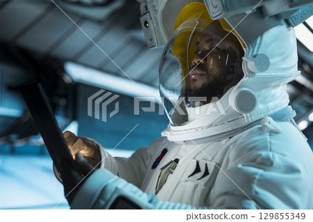 Close up of astronaut scientist operating spacecraft control interface using tablet. Researcher wearing cosmonaut gear in spaceship doing research, monitoring system diagnostics 129855349
