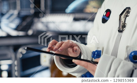 Astronaut monitoring life support systems before stepping out for scheduled operations outside space station. Cosmonaut verifying mission parameters after landing on red planet Astronaut monitoring life support systems before stepping out for scheduled operations outside space station. Cosmonaut verifying mission parameters after landing on red planet 129855369