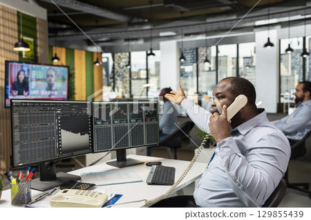 Trader desperately calling clients after stock market crash caused by Black Swan event causes them to lose money. Worried stockbroker in telephone call with customers to share recession news Trader desperately calling clients after stock market crash caused by Black Swan event causes them to lose money. Worried stockbroker in telephone call with customers to share recession news 129855439