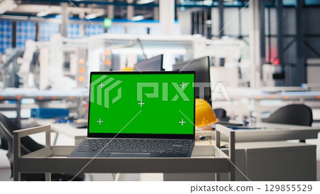 Isolated copy space display on laptop in solar cell manufacturing plant, solar power engineering for sustainable solutions and cheaper energy. Empty desk in a high tech factory. Isolated copy space display on laptop in solar cell manufacturing plant, solar power engineering for sustainable solutions and cheaper energy. Empty desk in a high tech factory. 129855529