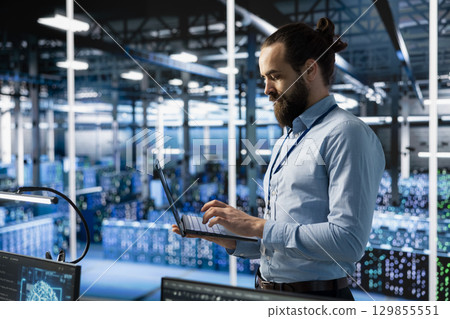 Programmer working in server farm with hardware supporting advanced analytics tasks and data mining. Data center IT expert doing maintenance on racks storing blockchain records Programmer working in server farm with hardware supporting advanced analytics tasks and data mining. Data center IT expert doing maintenance on racks storing blockchain records 129855551