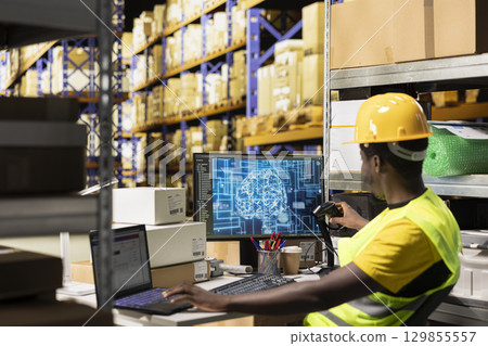 Employee uses AI brain automation to scan airway bill details on tags, registering barcodes with artificial intelligence machine learning system to fulfill e-commerce retail operations. 129855557