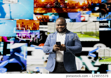 African American person engaged with mobile technology and multimedia feeds, showcasing the evolution of digital presence, communication and app interaction. Modern user interface. African American person engaged with mobile technology and multimedia feeds, showcasing the evolution of digital presence, communication and app interaction. Modern user interface. 129855578