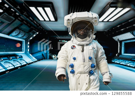 Cosmonaut in orbital station wearing helmet preparing for landing on alien planet. Man working on spaceship navigating orbital trajectory to extraterrestrial world, wearing equipment Cosmonaut in orbital station wearing helmet preparing for landing on alien planet. Man working on spaceship navigating orbital trajectory to extraterrestrial world, wearing equipment 129855588