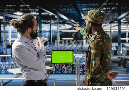 Military personnel overseeing AI computing operations on isolated screen in high tech server facility. Army tech experts using copy space screen to oversee communication systems. 129855591