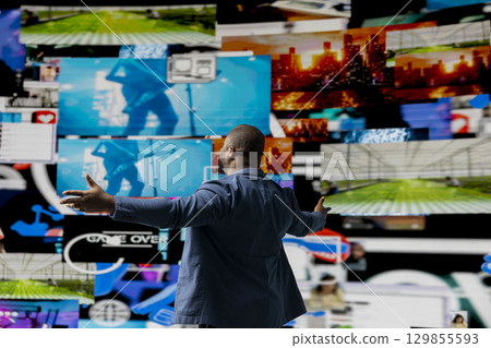 Black social media manager browsing high tech environment with app interfaces, infographics and social networking feeds. Showcases big data on social media platforms, multimedia. Black social media manager browsing high tech environment with app interfaces, infographics and social networking feeds. Showcases big data on social media platforms, multimedia. 129855593