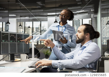 Prop firm coworkers collaborate on trading strategies in office, analyze market data together for better results. Brokerage colleagues discuss new opportunities and market trends 129855685