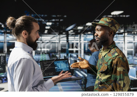 Diverse IT military experts in data center supervising autonomous defense systems on laptop screen. Armed forces personnel doing live drone tracking, command center mission for protection. Diverse IT military experts in data center supervising autonomous defense systems on laptop screen. Armed forces personnel doing live drone tracking, command center mission for protection. 129855879