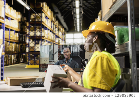 African american worker discussing with a male client on video call, sharing insight on parcel status and order tracking via customer support service. Staff member on e-commerce mix up. 129855905