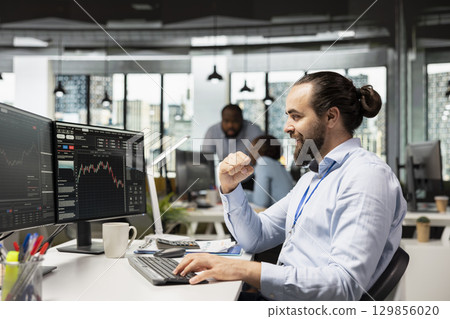 Joyous portfolio manager delighted by positive assets performance after adjusting holdings. Cheerful employee overseeing investment portfolios celebrating after maximizing returns for clients Joyous portfolio manager delighted by positive assets performance after adjusting holdings. Cheerful employee overseeing investment portfolios celebrating after maximizing returns for clients 129856020