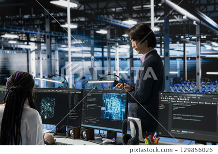 Data center developer monitoring AI systems, adjusting machine learning parameters. Server hub IT employee in office enhancing artificial intelligence software performance 129856026