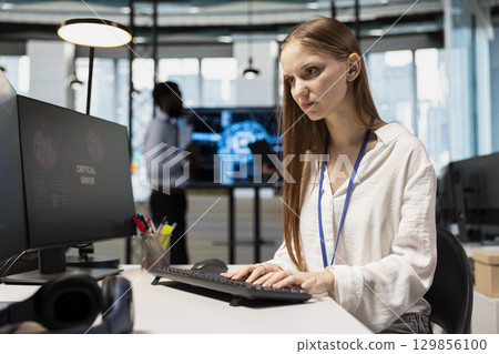 Female technician seeing critical error warning popup while adjusting deep learning algorithms parameters at work. Young worker receiving glitch failure alert while working with AI Female technician seeing critical error warning popup while adjusting deep learning algorithms parameters at work. Young worker receiving glitch failure alert while working with AI 129856100