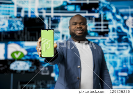 Black businessman using advanced technology and green screen on phone, exploring data science, automation and AI brain in a digital data visualization environment. Machine learning. Black businessman using advanced technology and green screen on phone, exploring data science, automation and AI brain in a digital data visualization environment. Machine learning. 129856226