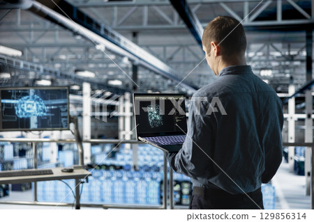 Data center IT specialist monitoring AI LLM visualization output to verify inference patterns. Programmer analyzing neural language network structure in server room using laptop Data center IT specialist monitoring AI LLM visualization output to verify inference patterns. Programmer analyzing neural language network structure in server room using laptop 129856314