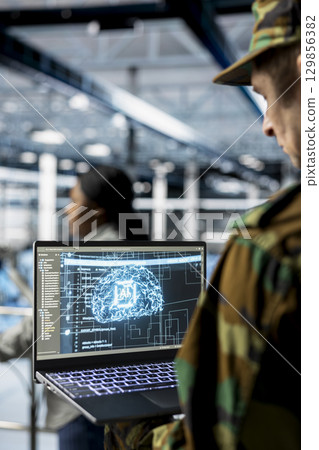 Close up of army tech expert in data center tracking threats using AI machine learning models. Server farm worker supporting autonomous systems with artificial intelligence technology 129856382