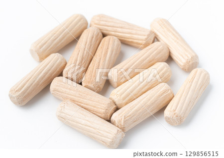 Wooden dowels on white background 129856515