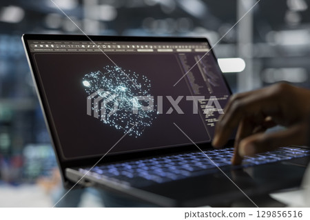 Close up of data center technician using laptop, running AI forecasting simulations, tracking performance. Server hub IT specialist uses notebook to integrate artificial intelligence API into software Close up of data center technician using laptop, running AI forecasting simulations, tracking performance. Server hub IT specialist uses notebook to integrate artificial intelligence API into software 129856516