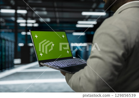 Close up of data center technician using green screen laptop, managing rigs energy consumption. IT specialist using mockup notebook used for monitoring processes in server room Close up of data center technician using green screen laptop, managing rigs energy consumption. IT specialist using mockup notebook used for monitoring processes in server room 129856539