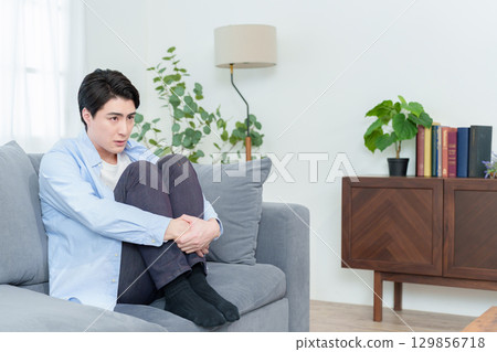 蹲在沙發上的男人 蹲在沙發上的男人 129856718