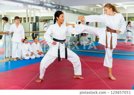 Young girl fighting with karate teacher 129857051